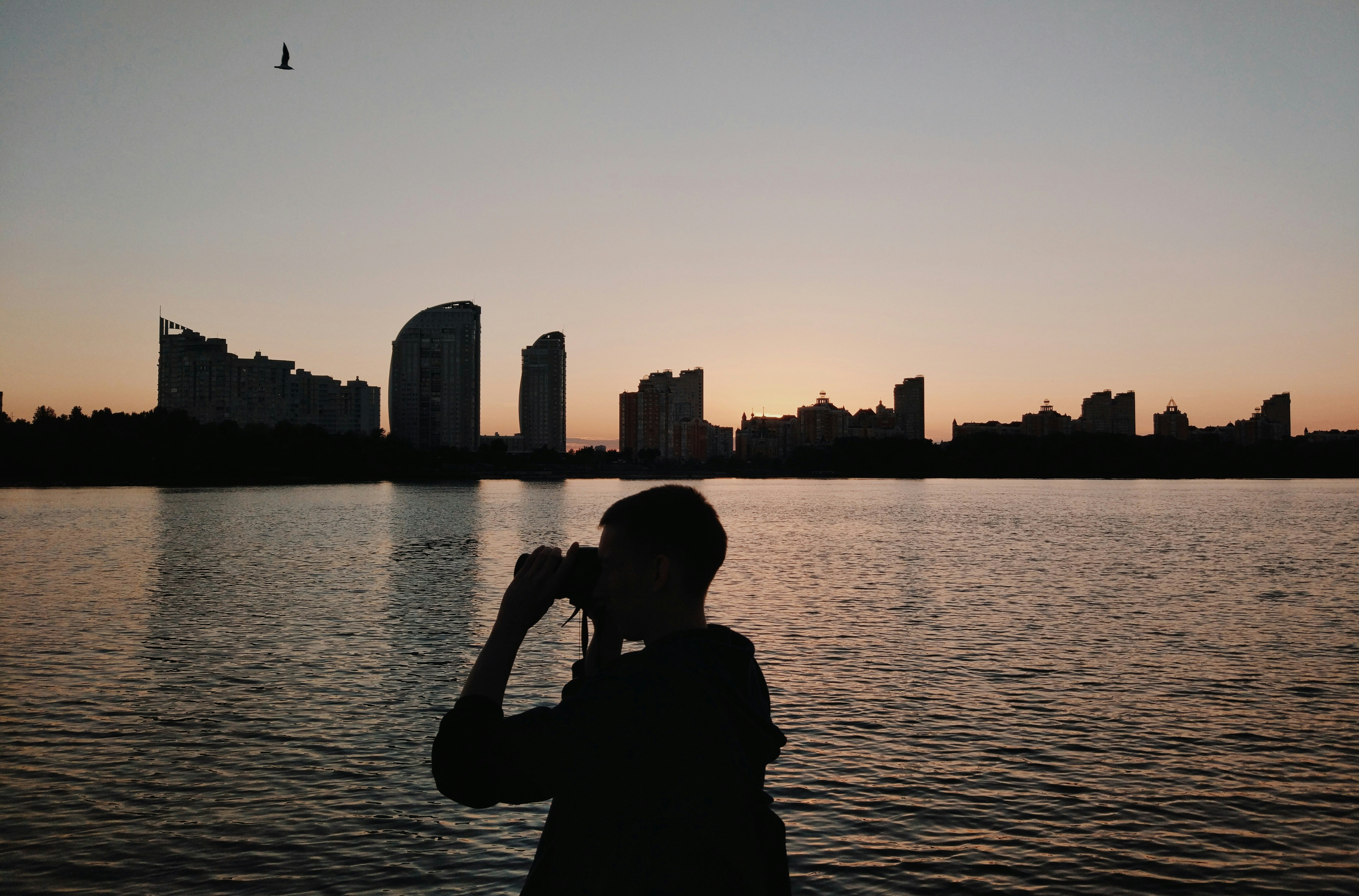 silhouette of person using binoculars